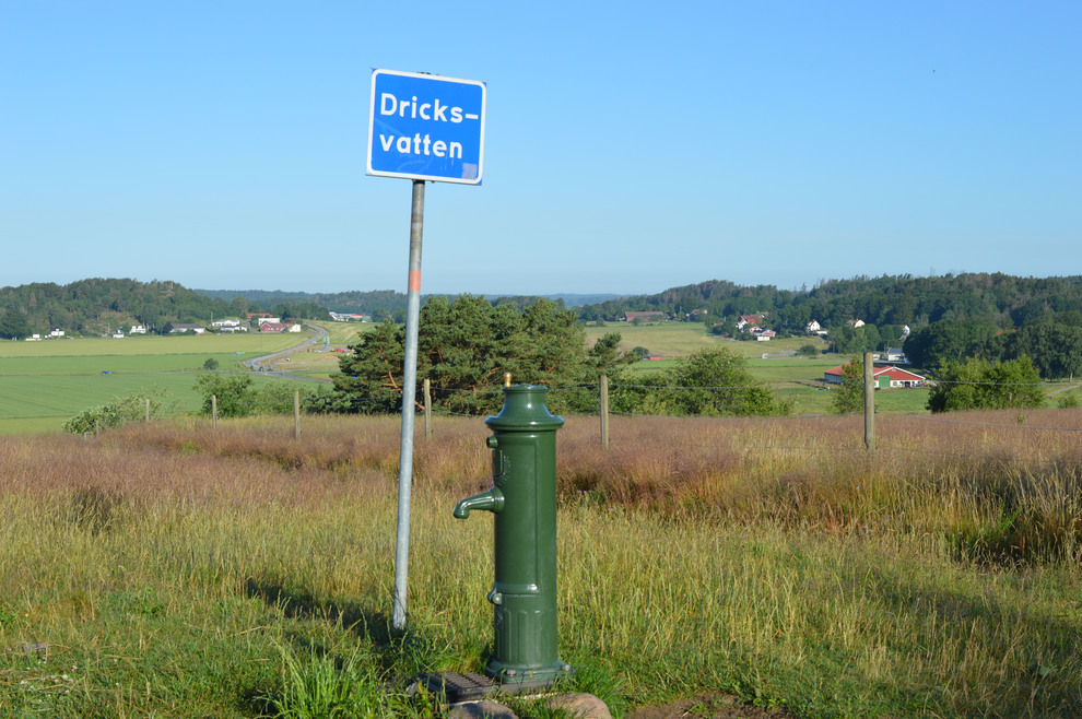 Skylt med texten "Dricksvatten" i landsbygdsmiljö.