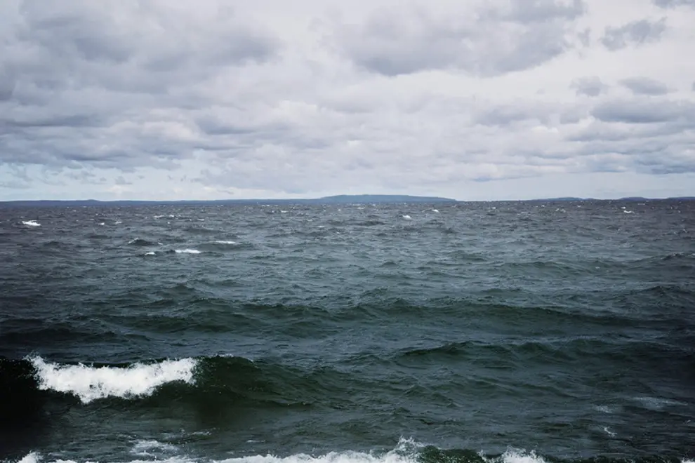 En stor vattenmassa med vågor som slår in mot stranden.