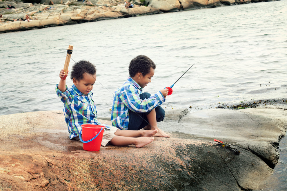 Pojkar på klippor som fiskar krabbor.