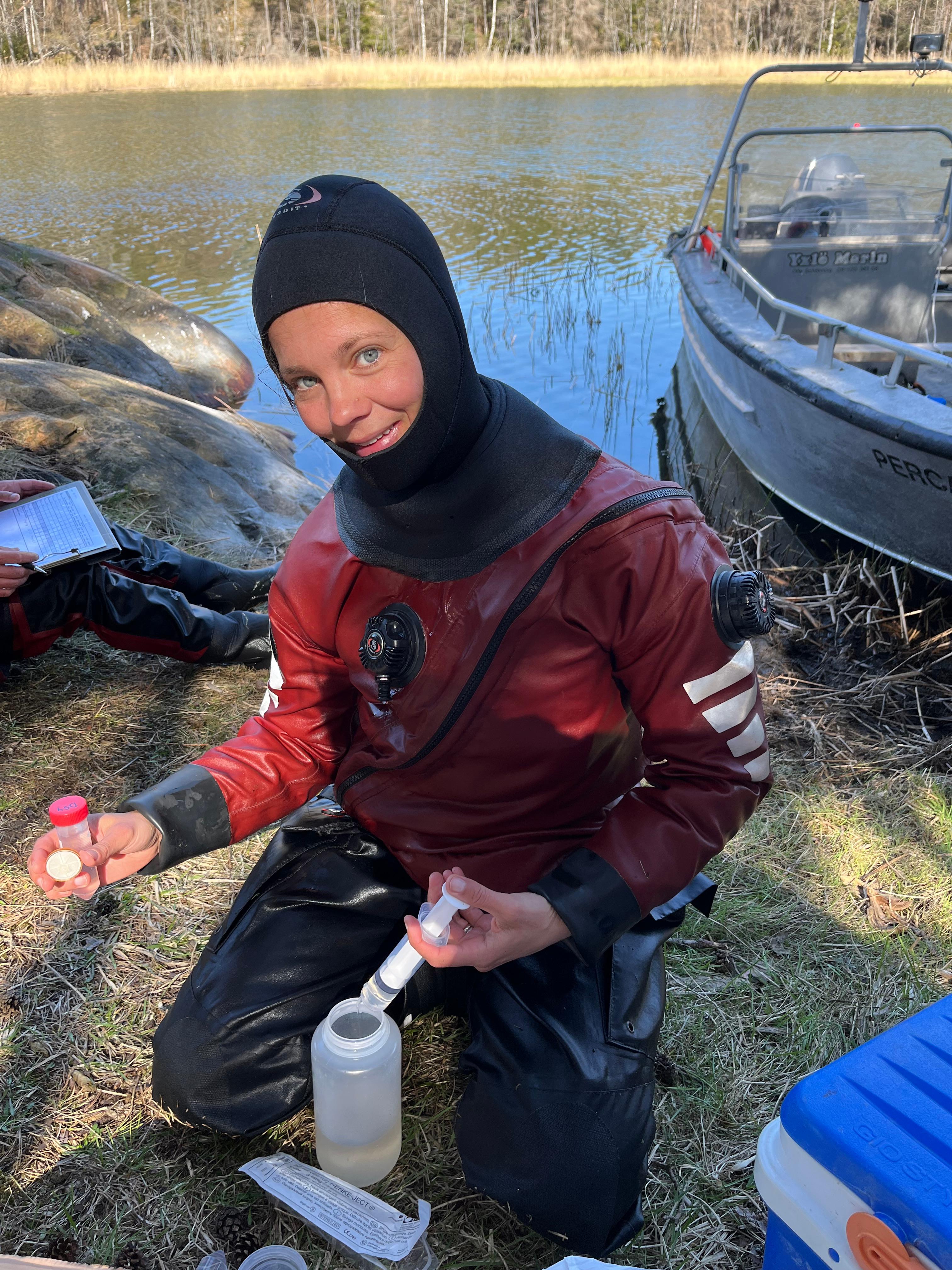 Åsa Nilsson Austin, en av forskarna i projektet Levande vikar, tar hand om vattenprover från en undersökning av hur småbåtar påverkar grumligheten i vattnet. Foto: Joakim Hansen
