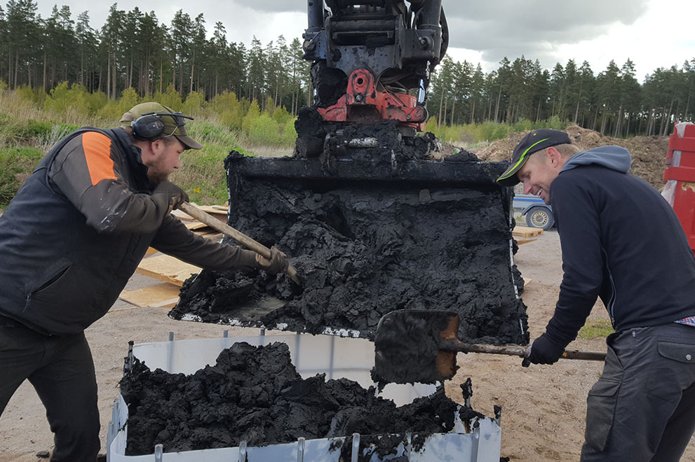 Avvattnat sediment lastas ur grävskopa för hand.