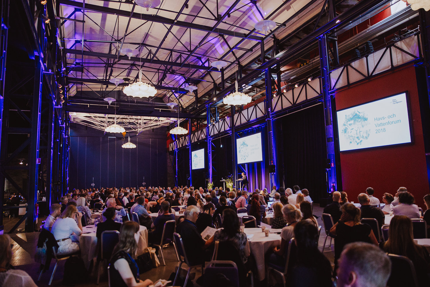 Publik tittar mot scen. På skärmar intill scenen syns texten Välkommer till Havs- och vattenforum 2018.