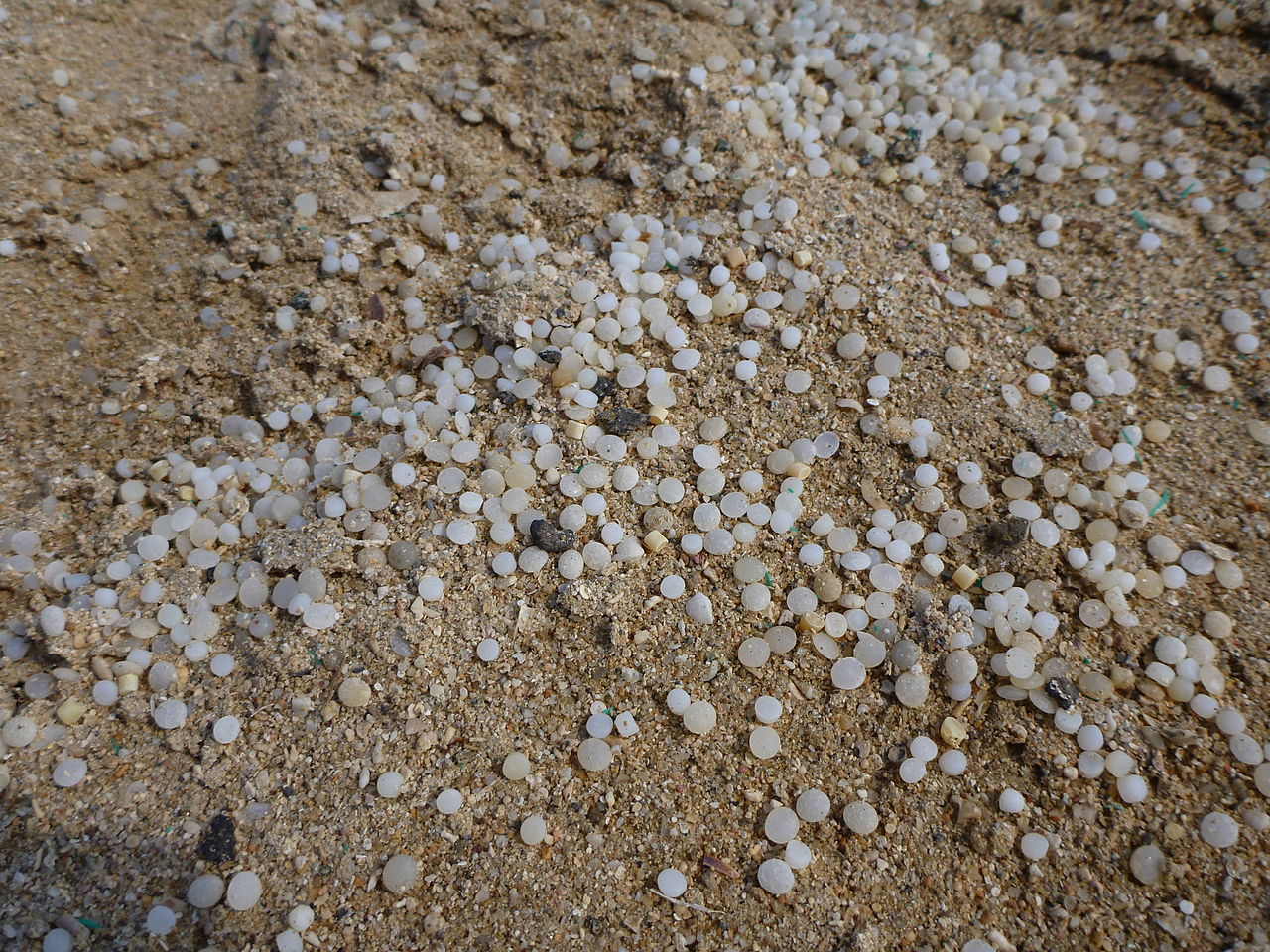 Plastpellets i sand.