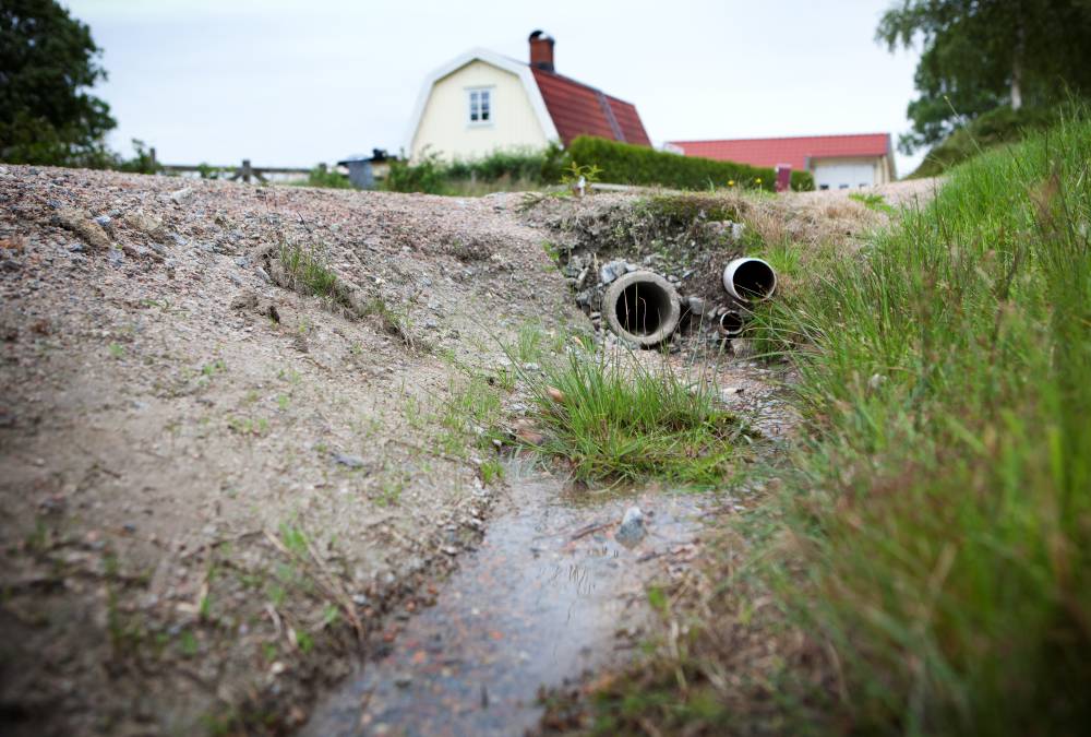 Avlopp. Hus i bakgrunden