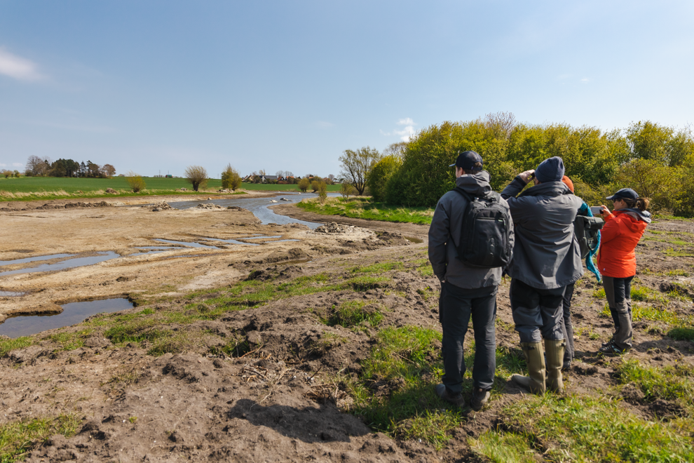 Tre människor vid en å