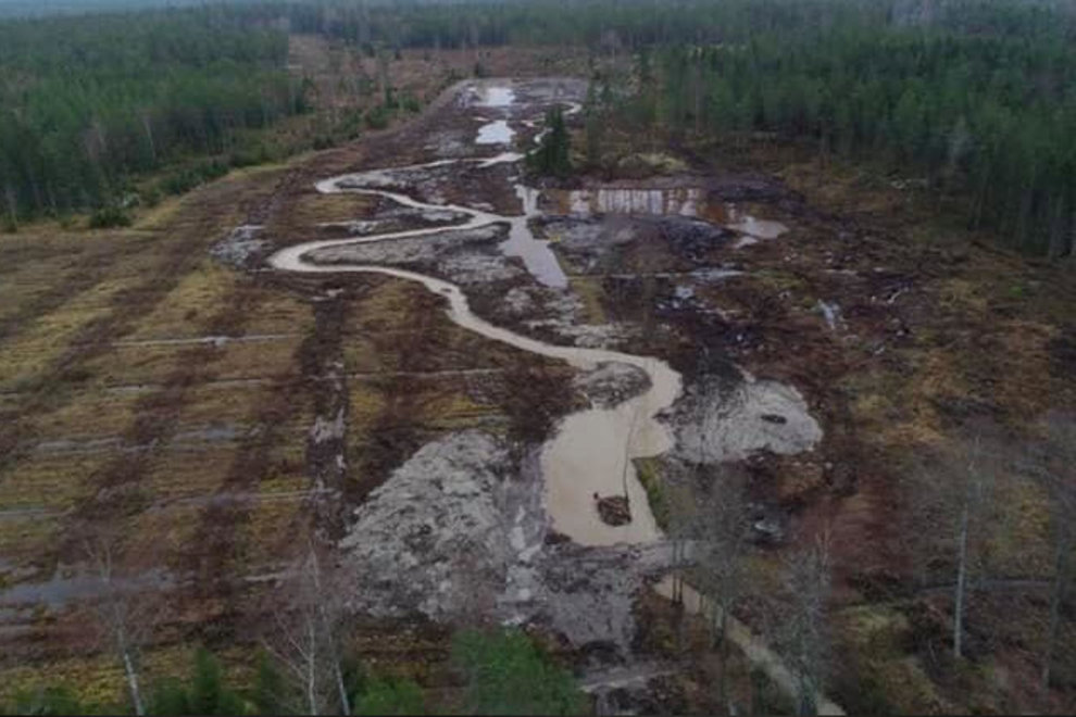 Flygfoto. Skogen är borta. Kärret har fått en ringlande väg.